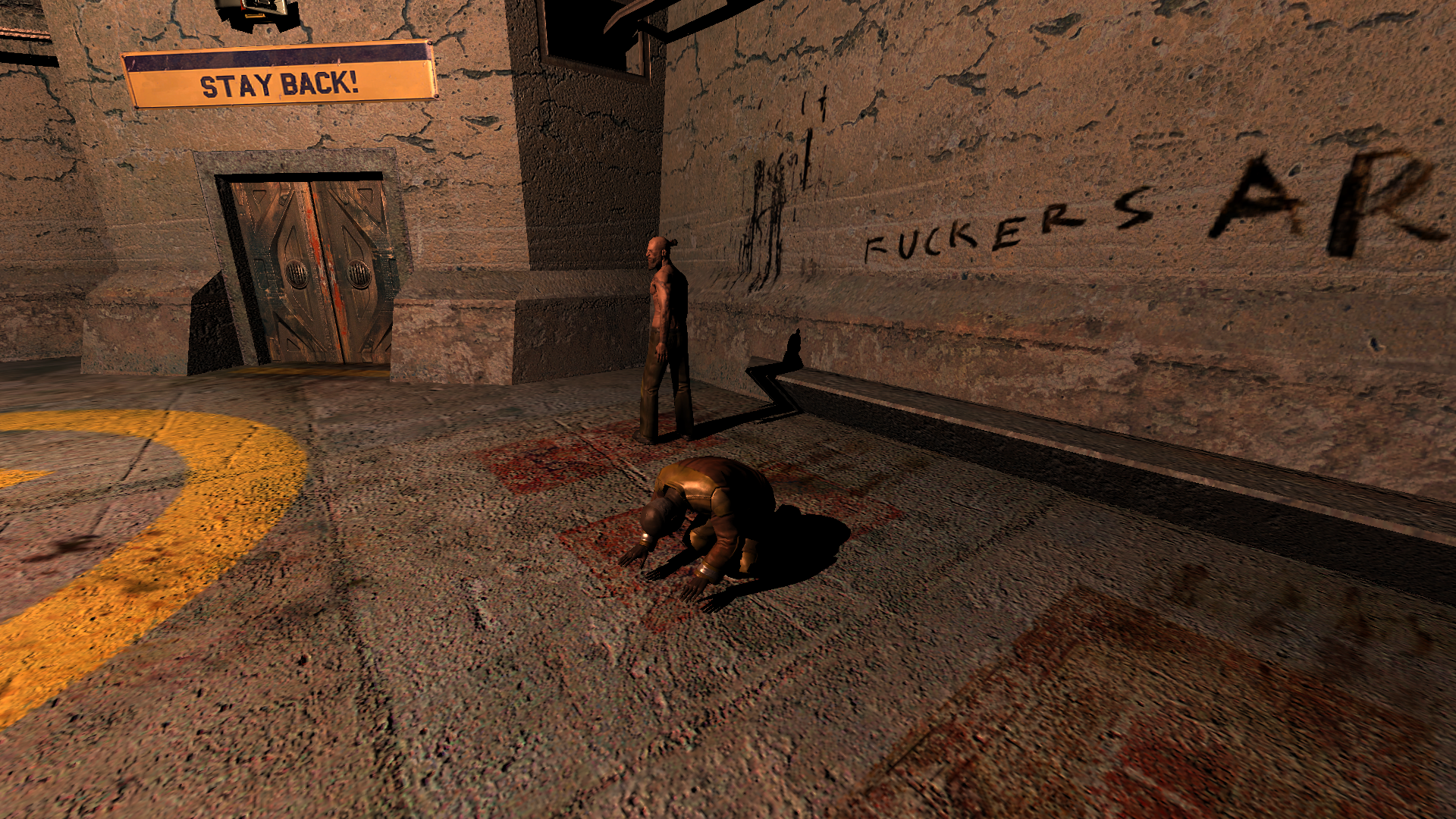 Two inmates in an open concrete room, a bench on the wall behind them. One stands in the background looking away and the other kneels on a patch of faded paint on the concrete that vaguely resembles a prayer mat. The graffiti on the wall behind them says 'FUCKERS AREA', but is cut off.