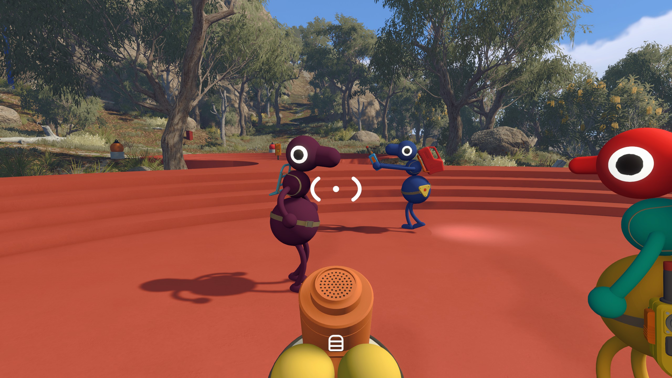 A screenshot from Big Walk, in which three cartoonish characters are walking around on a solid red platform with photorealistic trees in the background. In the foreground, a megaphone is held by the first-person-perspective player, hanging forward.