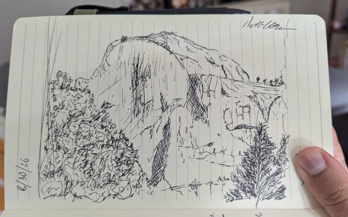 A notebook page with an ink sketch of Half Dome, a large rounded rock in Yosemite national park, as seen from the valley floor. Trees frame it in the foreground.